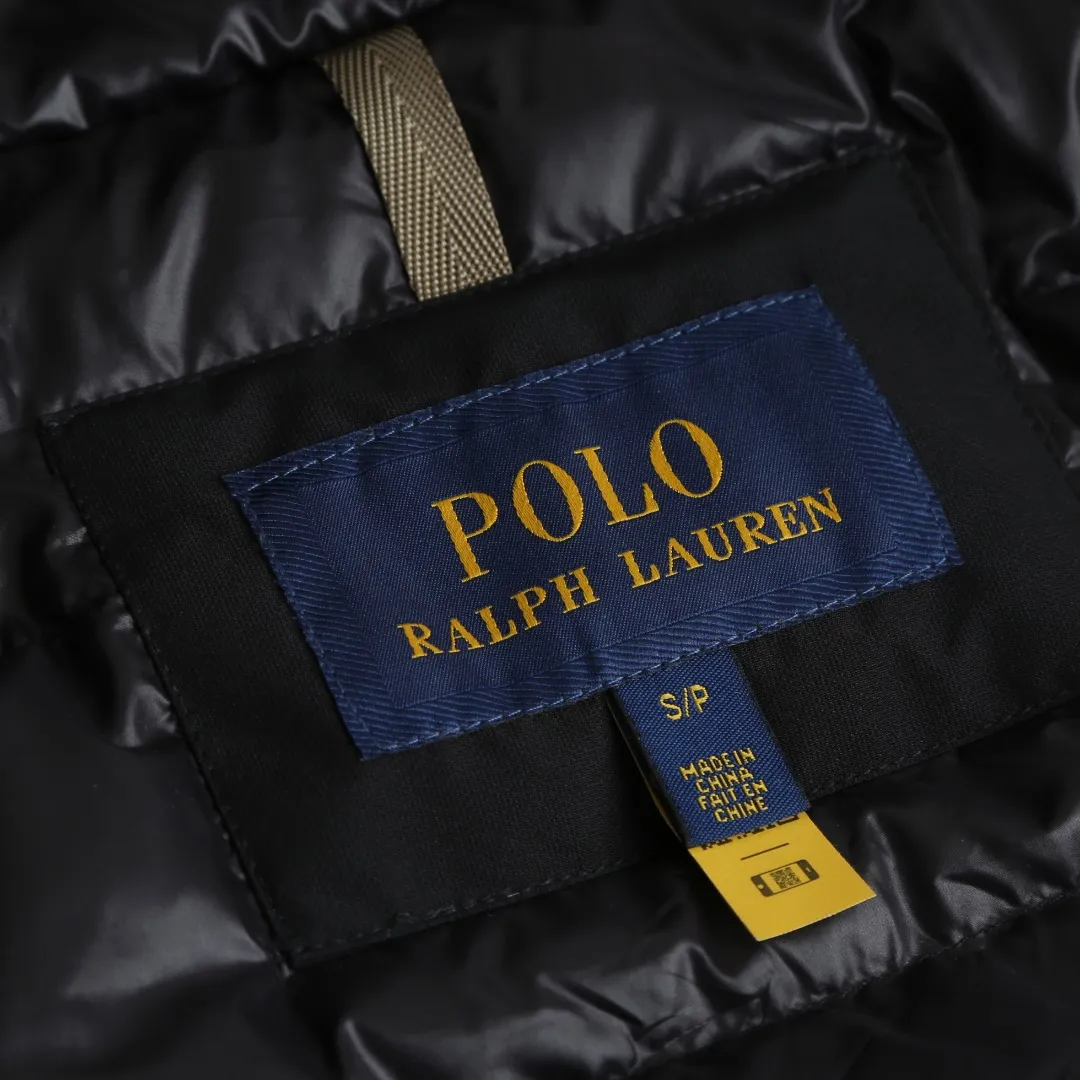 P970 Ralph Lauren Logo Hooded Down Jacket Fabric selection: High-density nylon taffeta with a density of about 210T-300T, smooth and slightly matte surface, excellent windproof and waterproof performance (with DWR water-repellent treatment), strong wrinkle resistance and easy care, in line with the "durable and practical" positioning of American leisure.  Lining fabric: 100% polyamide is used to create the lining. The high-density and tight weaving process prevents fine lint from emerging from the gaps in the fabric. The smooth surface improves the putting on and taking off experience, and the excellent wear and tear resistance ensures damage caused by frequent use, while the light and soft texture does not affect the overall weight.  High-quality filling: 90 white duck down is selected, with a weight of 220g, ensuring excellent thermal insulation performance. After strict screening and processing, the velvet is not easy to drill, ensuring durability. Style and cutting process: The classic jacket has a slightly loose fit, with a slightly dropped shoulder line (the shoulder width is 1-2cm wider than the standard fit). The length reaches the hips, and the sleeves are slightly tapered straight sleeves, taking into account freedom of movement and casual style.  Details: The adjustable Velcro on the cuffs allows you to freely adjust the tightness according to the thickness of your wrist and personal preferences, effectively preventing cold wind from intruding, and improving warmth retention performance.  In terms of storage, the two front zipper pockets are convenient for you to place frequently used items, and the zipper design ensures that items are not easily lost. A built-in pocket on the left side of the chest provides a safe storage space for some small private items.  The drawstring design at the hem allows you to adjust the shape of the jacket according to your body shape and dressing needs. Whether it is loose and casual or slim and neat, you can easily control it.  Embroidery technology: Polo horse logo on the left chest: flat satin stitch embroidery (satin embroidery), embroidery thread: 100% polyester high color fastness embroidery thread (the color number is consistent with the brand’s standard red color card), stitch density 12-15 stitches/cm, the outline of the horse logo is clear, and the details of the rider and horse are burr-free.  Embroidery positioning: precise positioning through the template (12cm from the neckline and 8cm from the placket) to ensure left and right symmetry and centering.  Accessories: One-to-one customized zipper sling, one-to-one customized zipper puller, one-to-one customized washable label SIZE: S M L XL